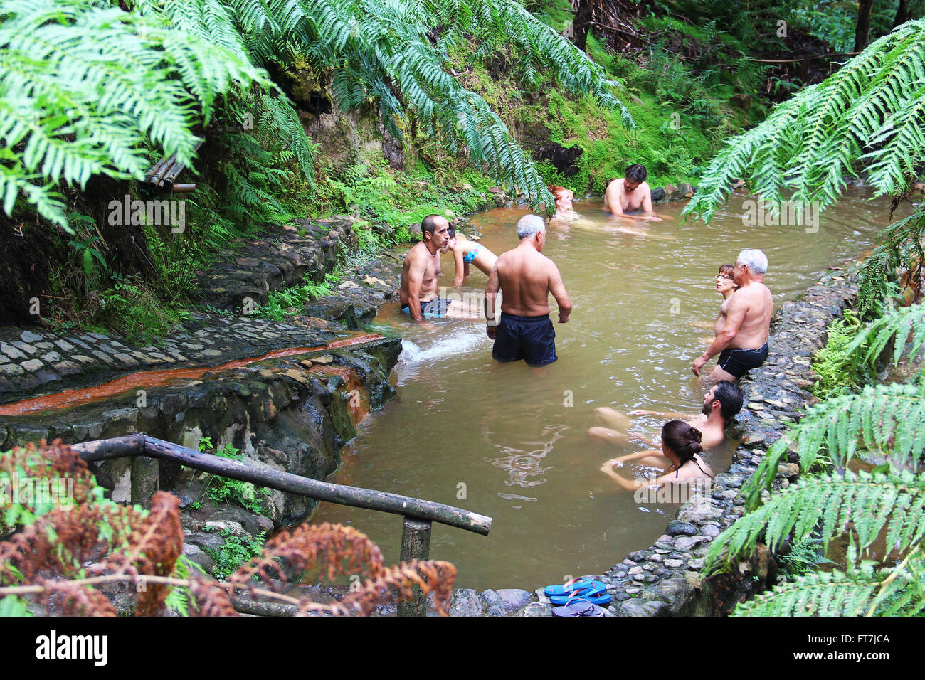 Menschen genießen Sie Bad in natürlichen Thermalbädern der Caldeira Velha auf der Insel Sao Miguel, Azoren, Portugal Stockfoto