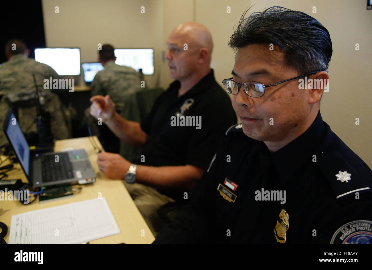 U.S. Customs and Border Protection Officer Tanai Saefong, Recht, mans CBP Post eine behördenübergreifende Operations Center in Santa Clara, Kalifornien, als Bundes- und lokalen Agenturen Ramp-up Sicherheitsoperationen für Super Bowl 50 3. Februar 2016. (U.S. Customs and Border Protection Foto von Glenn Fawcett) Stockfoto