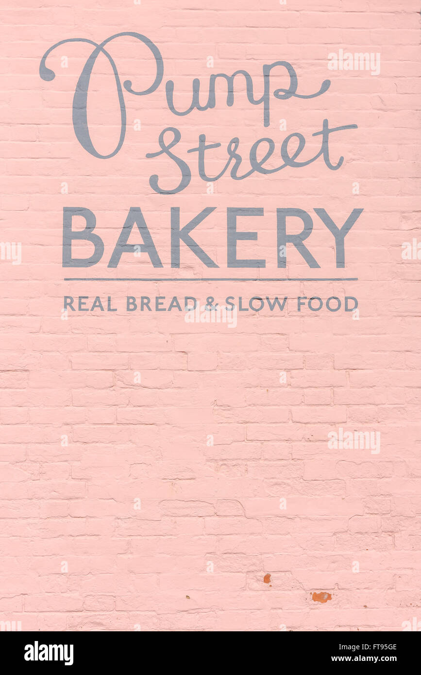 Suffolk-Essen, Blick auf die Beschilderung und die rosa Wand der Pump Street Bakery, einer beliebten handwerklichen Bäckerei in Orford, Suffolk, England Stockfoto