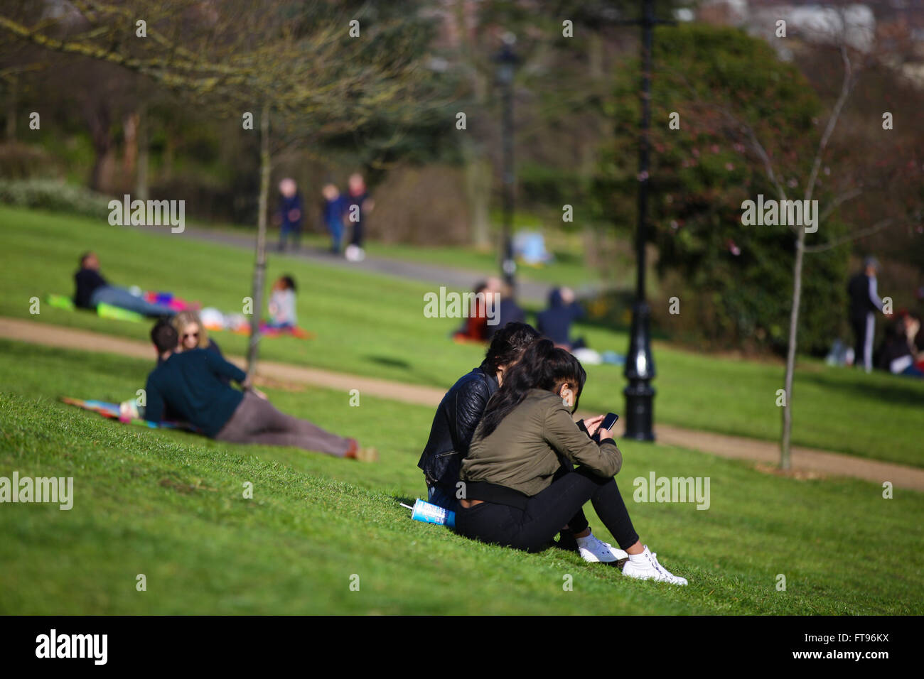 Nord-London, UK. 25. März 2016. Leute sitzen, Wandern, bewundern Sie die Aussicht und machen zu lesen, das Beste aus einem Tag feine Sonnenstrahlen im Alexandra Palace in Nord-London am Karfreitag - starten von Ostern Wochenende von Feiertagen Credit: Dinendra Haria/Alamy Live News Stockfoto