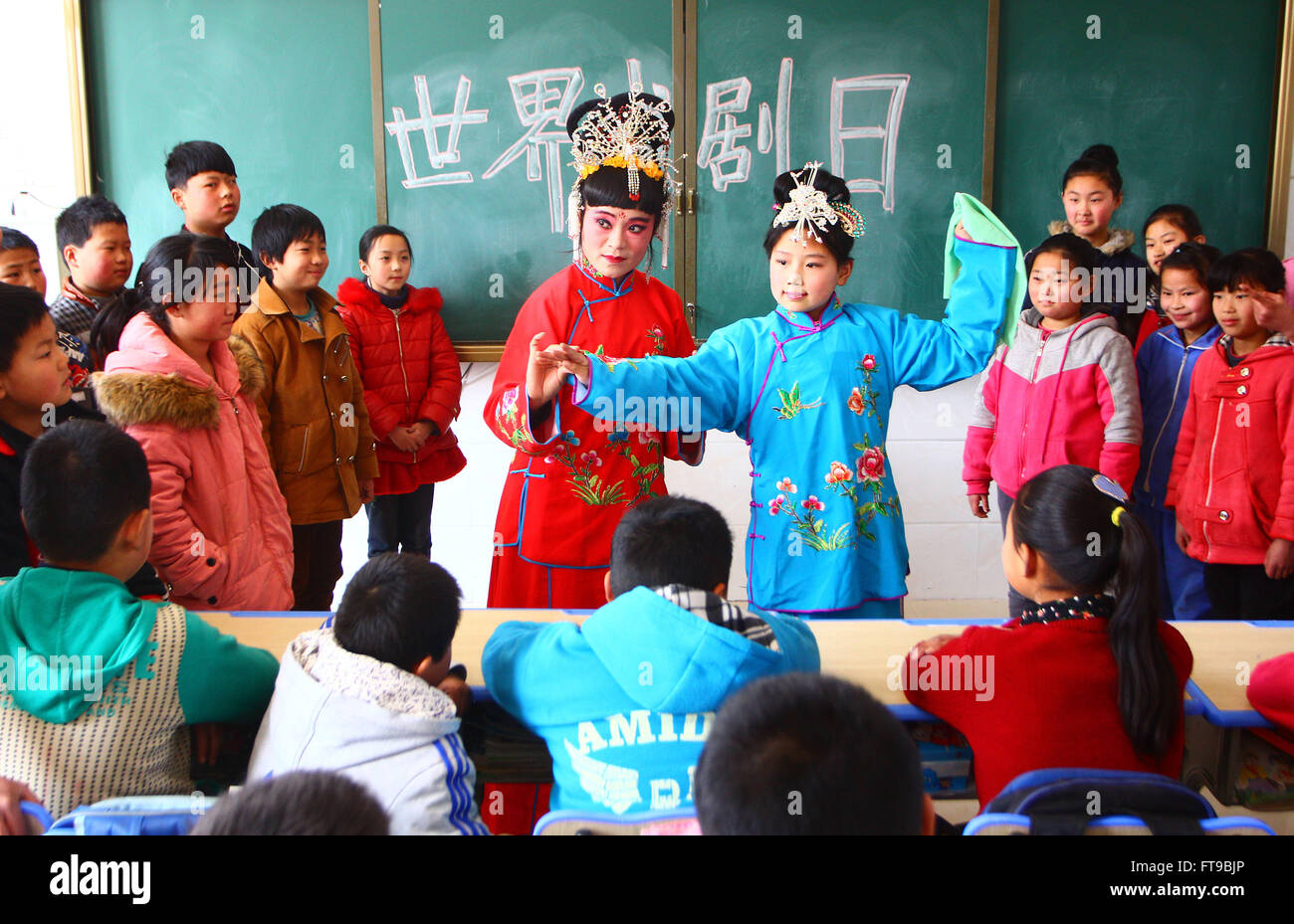 Zaozhuang, China Shandong Provinz. 25. März 2016. -Opera-Darstellerin Shao Hong weist Studenten Zhao Yanyang in Donglu Elementary School in Zaozhuang City in der ostchinesischen Provinz Shandong, 25. März 2016 durchführen. Oper Schauspieler durften Schüler als die Welt-Theater-Tag Ansätze Opern beizubringen. Die Welt-Theater-Tag wurde im Jahr 1961 von des Internationalen Theaterinstituts erschaffen. Es wird jedes Jahr am 27. März von Theater Unternehmen Aournd der Welt gefeiert. Bildnachweis: Zhang Qiang/Xinhua/Alamy Live-Nachrichten Stockfoto