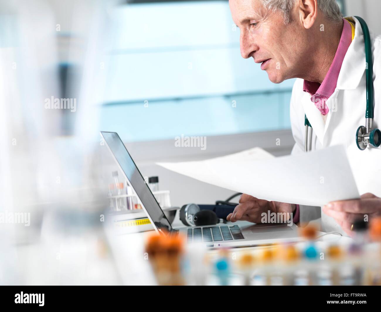 EIGENTUM FREIGEGEBEN. -MODELL VERÖFFENTLICHT. Arzt den Zugriff auf Patientenakten auf Laptop und medizinischen Unterlagen. Stockfoto