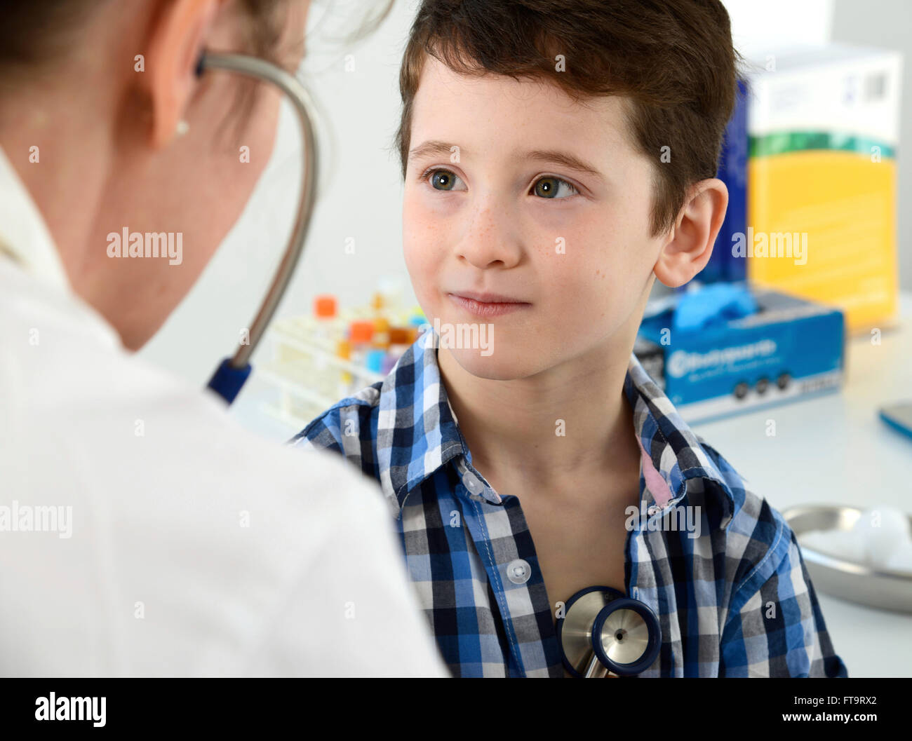 -MODELL VERÖFFENTLICHT. Allgemeinmedizin Arzt drückt ein Stethoskop auf der Brust eines kleinen Jungen. Stockfoto