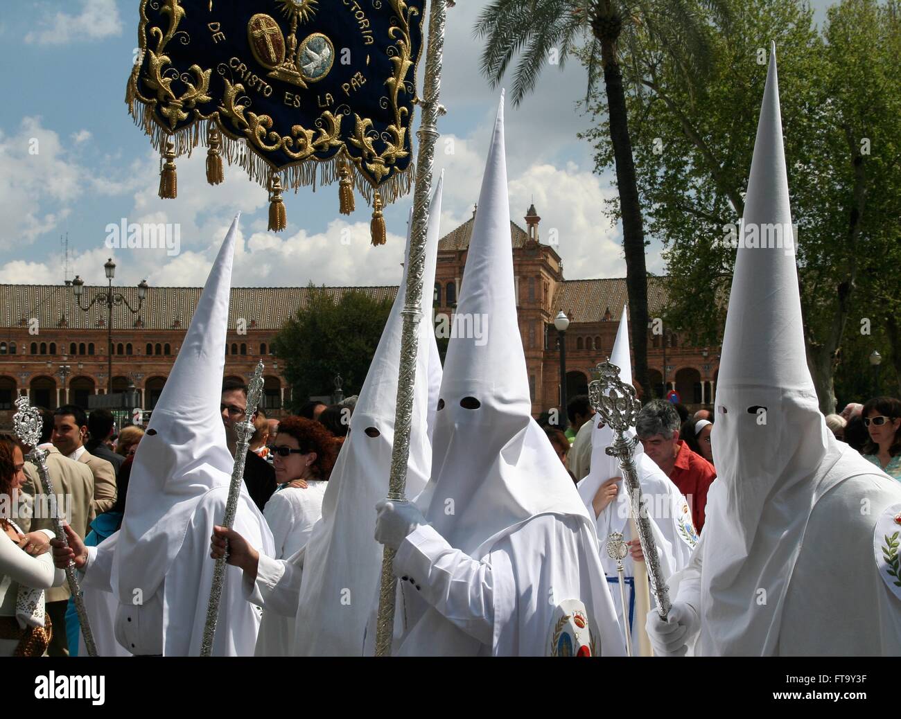 Eine katholische Büßer, die Zugehörigkeit zu einer Cofradias oder religiösen Bruderschaften tragen traditionelle Spitzen Hauben während einer Osterprozession im Rahmen der Karwoche in Sevilla, Spanien. Stockfoto