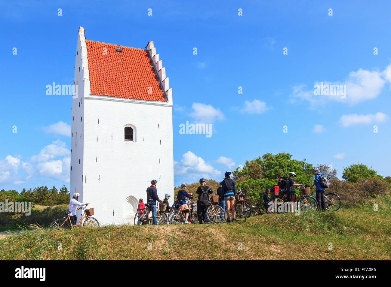 Radfahren Jugendlichen am Sand bedeckten Kirche in Skagen, Dänemark Stockfoto