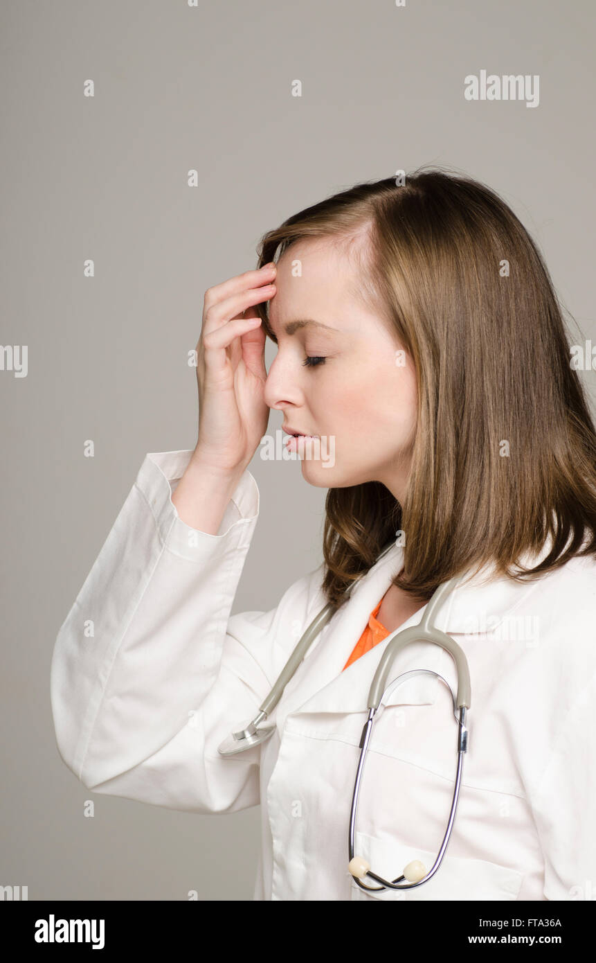 Profil einer müde Ärztin Hand auf Kopf Stockfoto