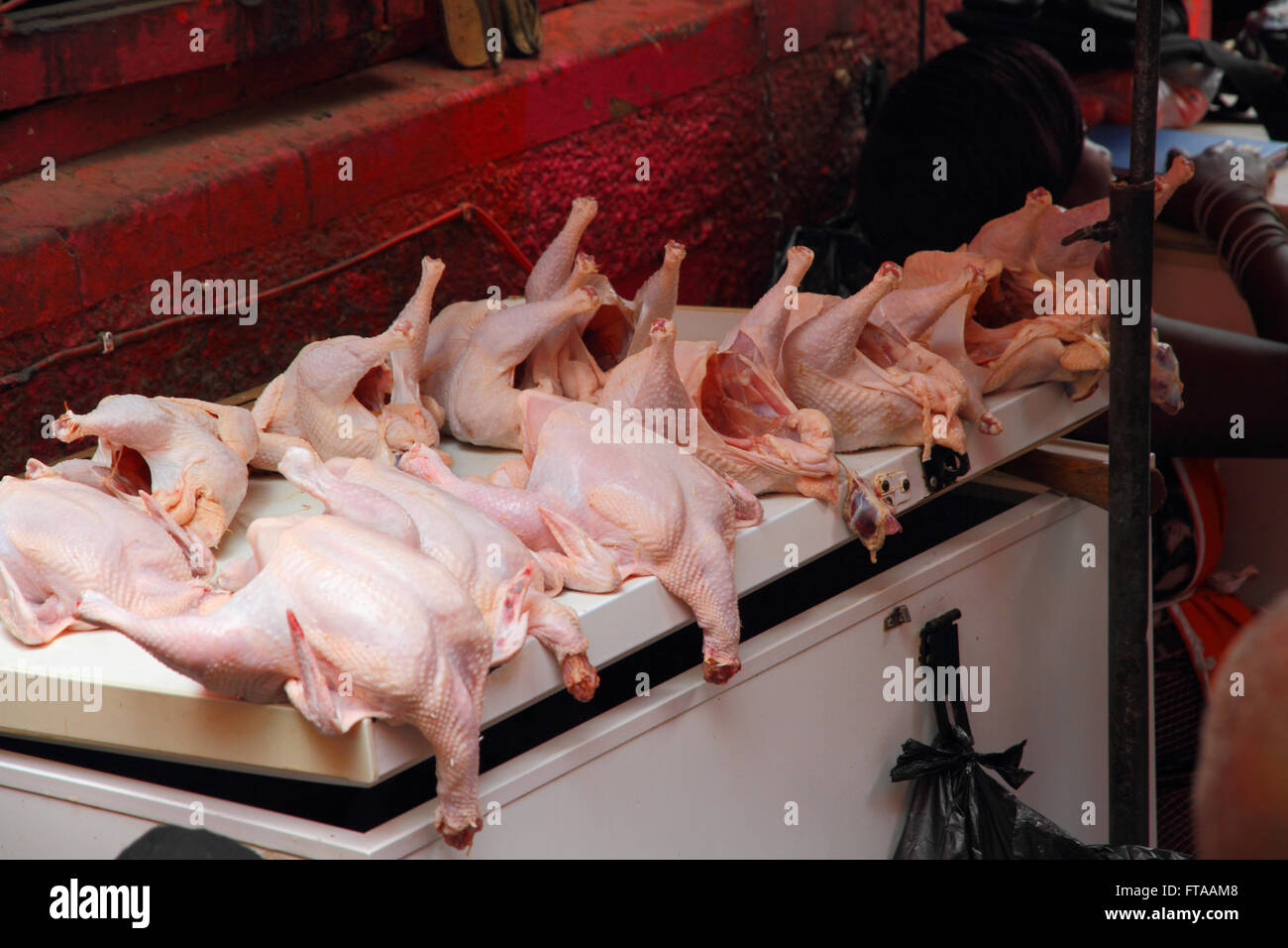 Hühnerschlachtkörpern für den Verkauf in einem offenen Luft afrikanischen Markt und Anzeigen auf einem Gefrierschrank Deckel. Stockfoto