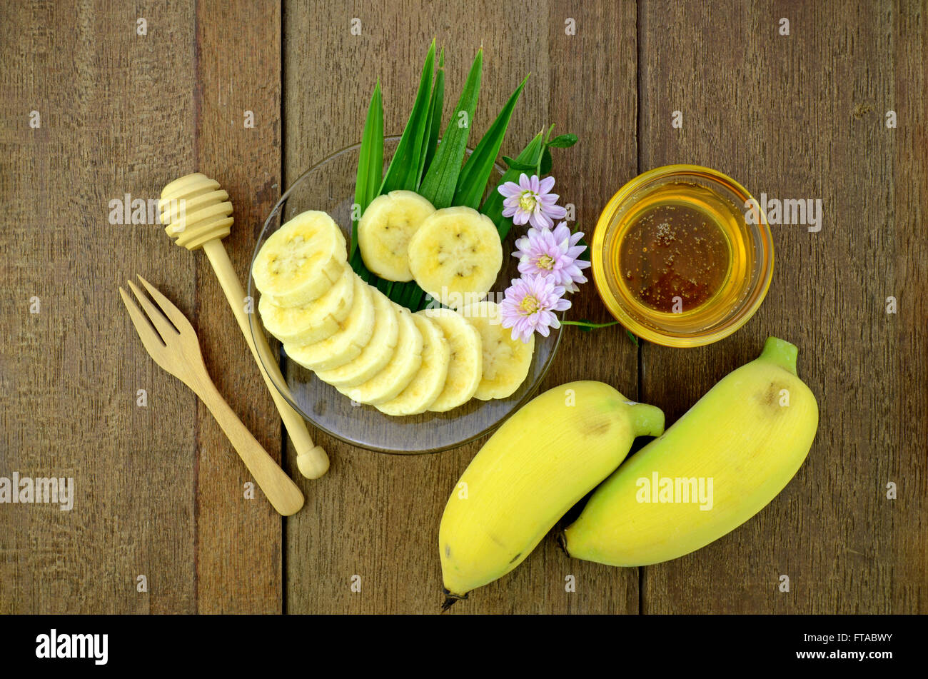 Thai Schönheit und Anti-Aging-Dessert-Rezept. Bananen (Musa Sapientum Linn.) mit Honig auf natürliche Holz Hintergrund kultiviert. Stockfoto