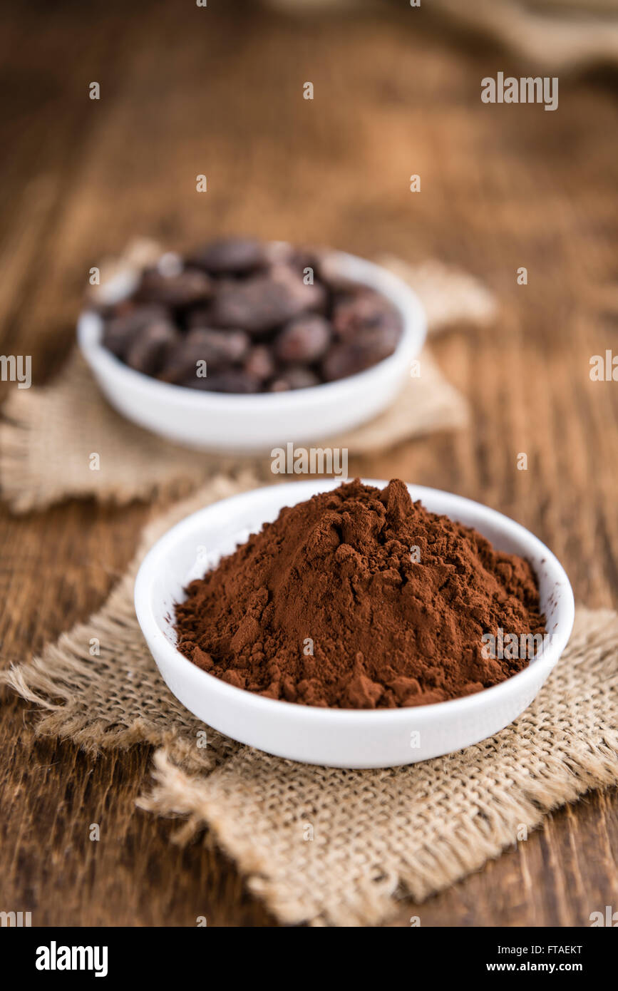 Kakaopulver (Tiefenschärfe) als detaillierte Nahaufnahme auf hölzernen Hintergrund Stockfoto