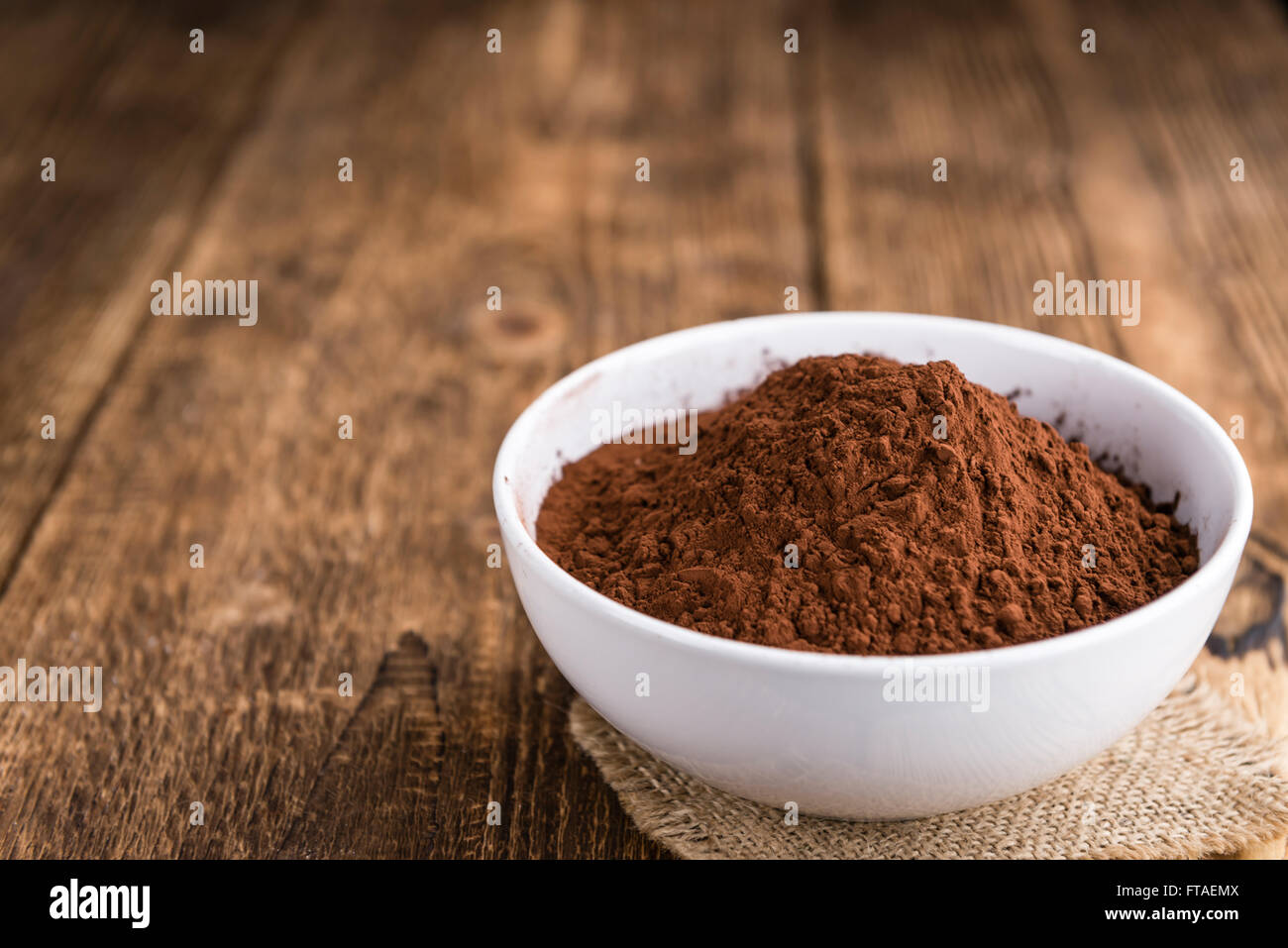 Teil des natürlichen Kakao-Pulver auf einem alten Holztisch (Tiefenschärfe) Stockfoto