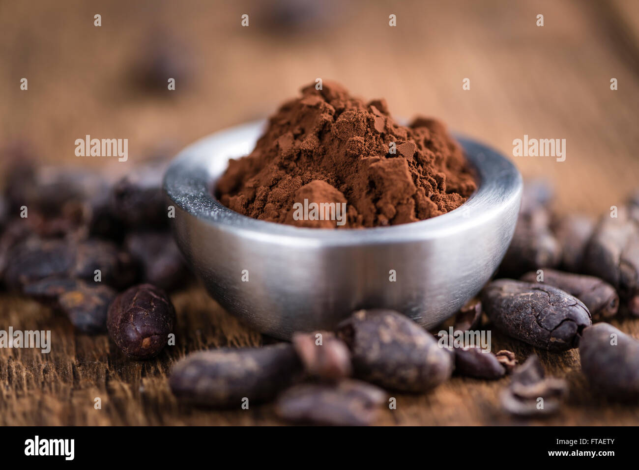 Natürlichen Kakao-Pulver (detaillierte Nahaufnahme) auf einem alten Holztisch (Tiefenschärfe) Stockfoto