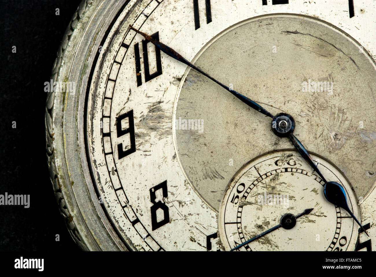 Makro-Ansicht von zerkratzten Gesicht eine alte Taschenuhr auf einem schwarzen Hintergrund. Stockfoto