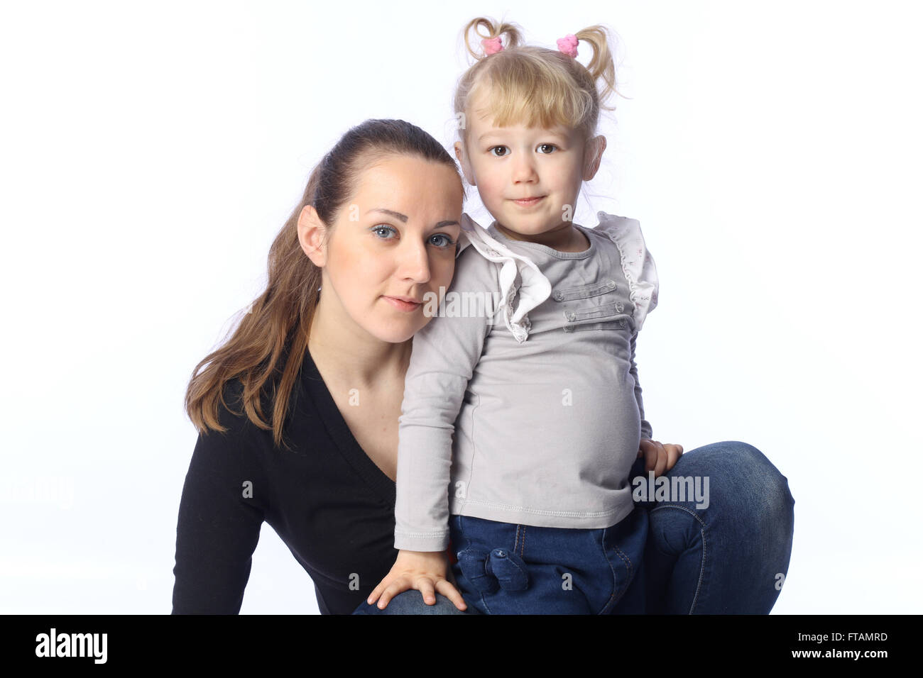 Mutter und kleine Tochter suchen auf den Betrachter Stockfoto