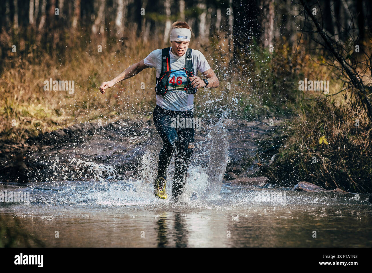 Belorezk, Russland - 26. September 2015: Läufer Mann mittleren Alters überquert ein Gebirgsfluss während Marathon Mountain "Große Dusche" Stockfoto