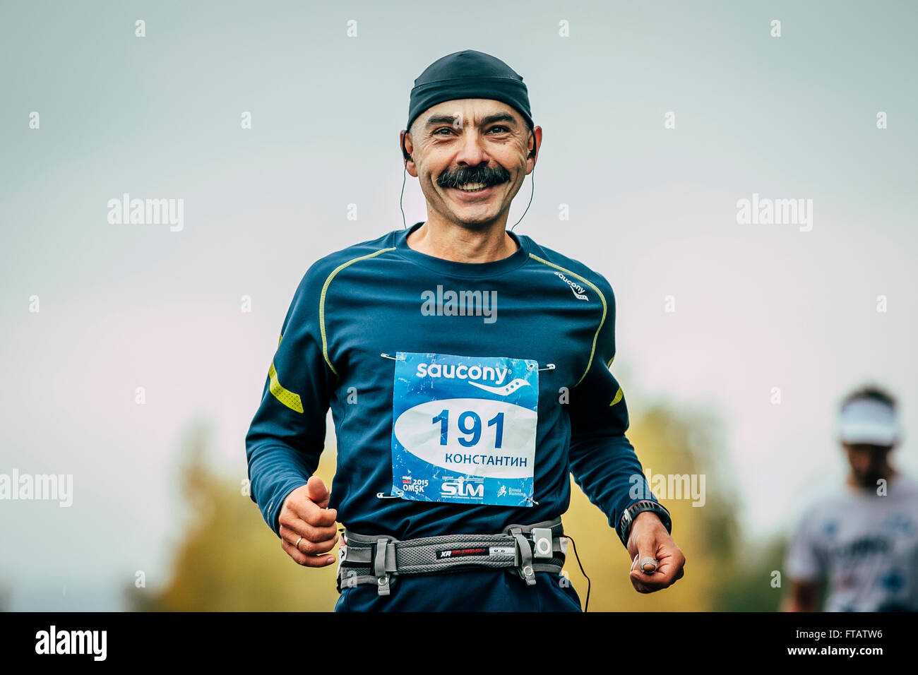 Omsk, Russland - 20. September 2015: attraktive Sportler Läufer im mittleren Alter Abstand laufen und Lächeln während der sibirischen marathon Stockfoto