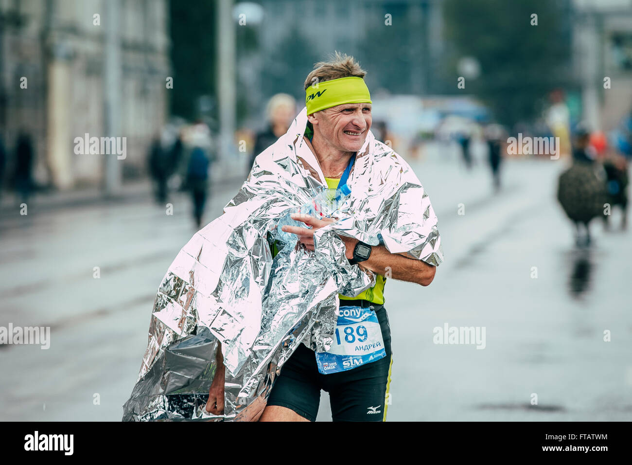Omsk, Russland - 20. September 2015: Sportler Läufer nach dem Zieleinlauf setzen auf Alufolie bei sibirischen Marathon im mittleren Alter Stockfoto