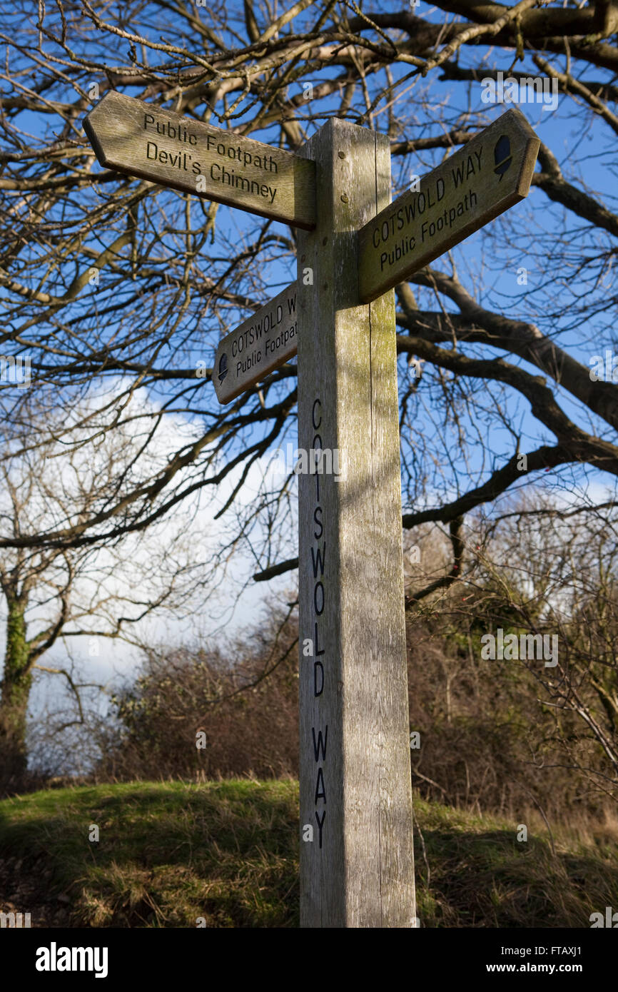 Familie gehen am Leckhampton Hügel Teil des Cotswold Weise Rout Trhough die Cotswolds in Cheltenham in Großbritannien. Zeigt sich hier post eine alte Holzschild Regie Wanderer auf den Pfaden der Route. Stockfoto