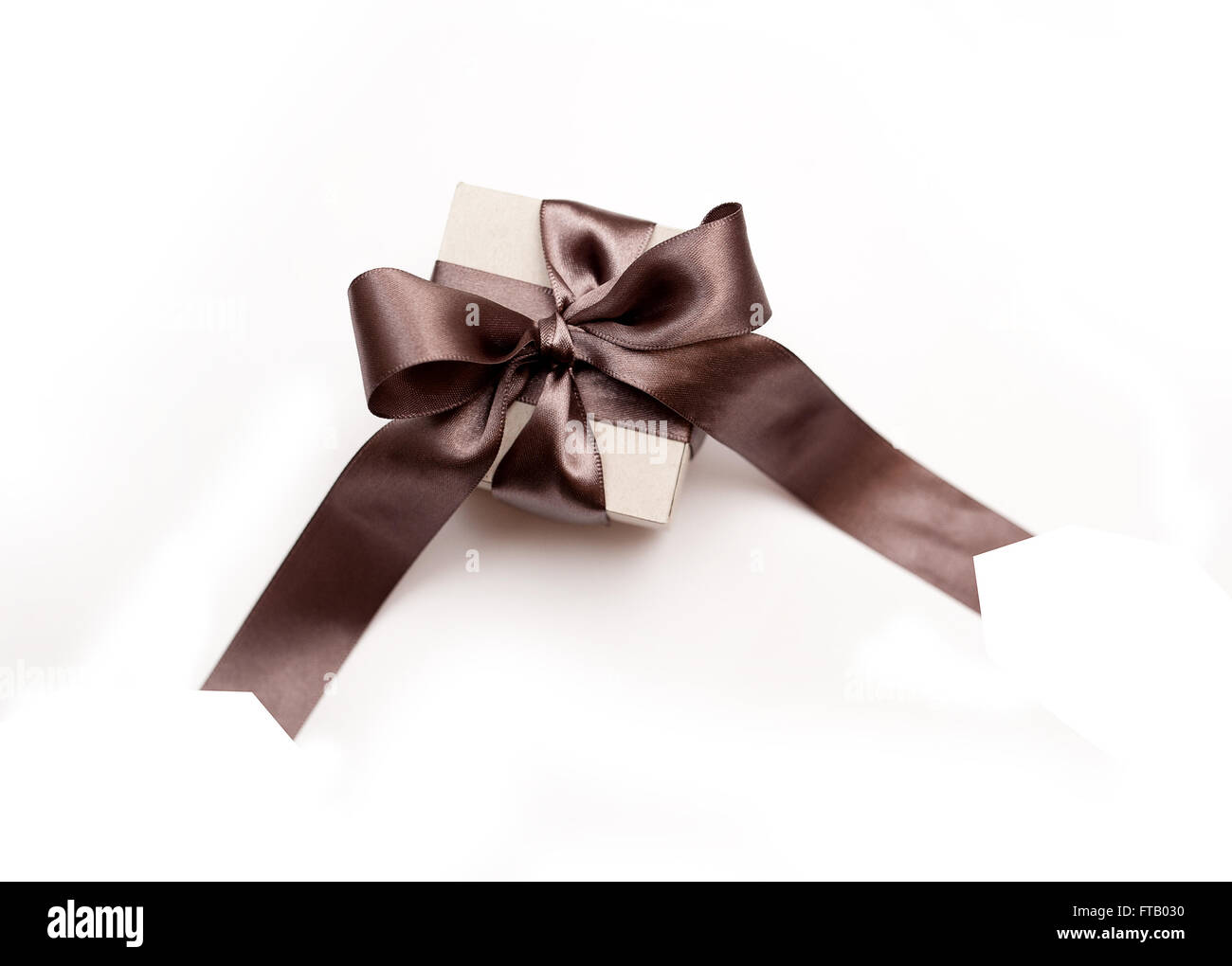 Geschenkbox mit braunen Bogen auf weißem Hintergrund Stockfoto