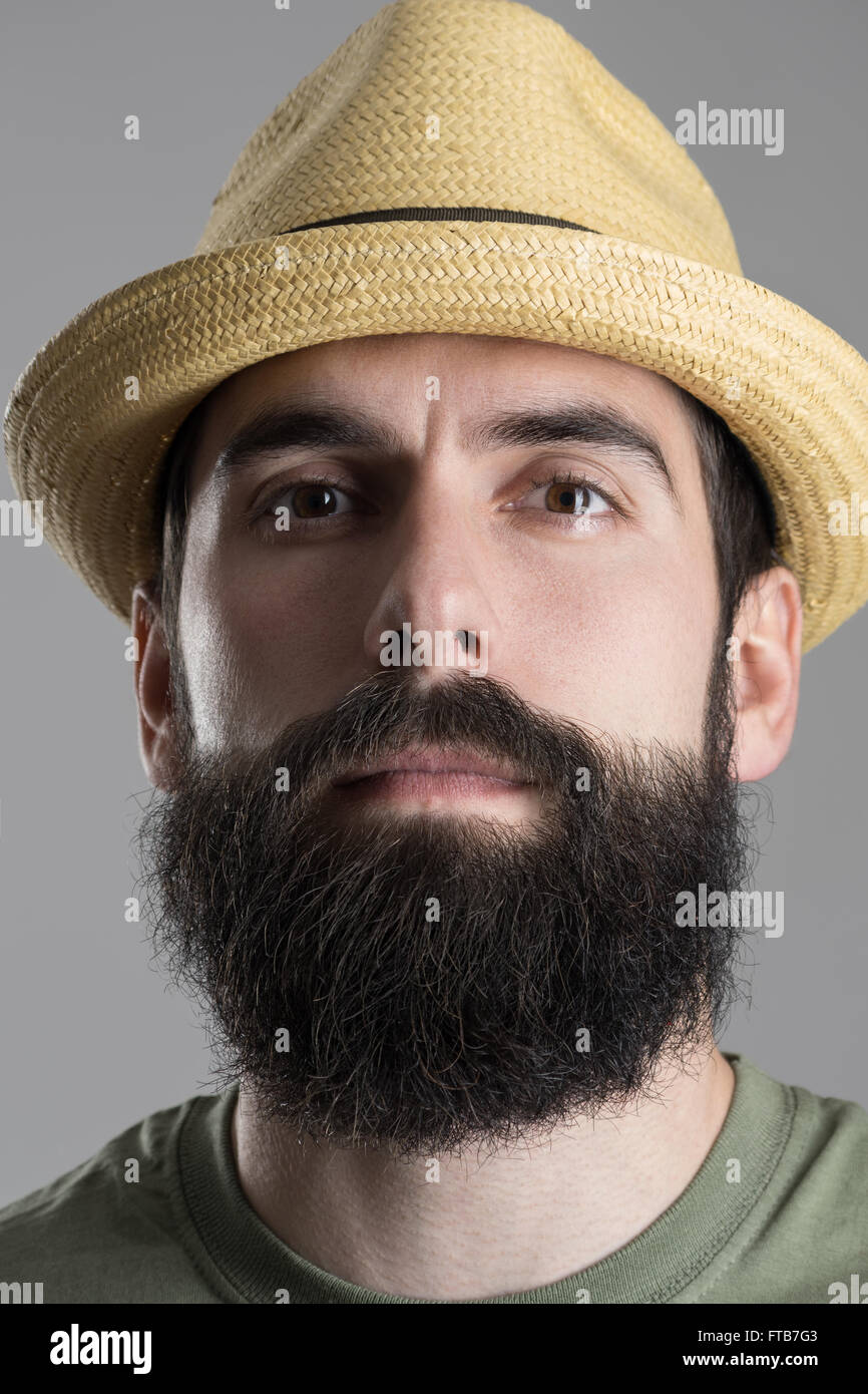 Porträt von sicher stolz Hipster Stroh Hut Blick in die Kamera hautnah. Kopfschuss über graue Studio-Hintergrund. Stockfoto