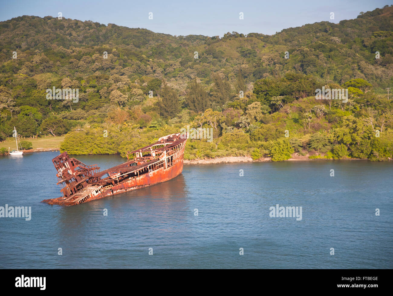 Gesunkenes Schiff sitzen in Mahagoni Bar in Roatán, Honduras mit den Inseln üppige Vegetation auf den Hügeln im Hintergrund Stockfoto