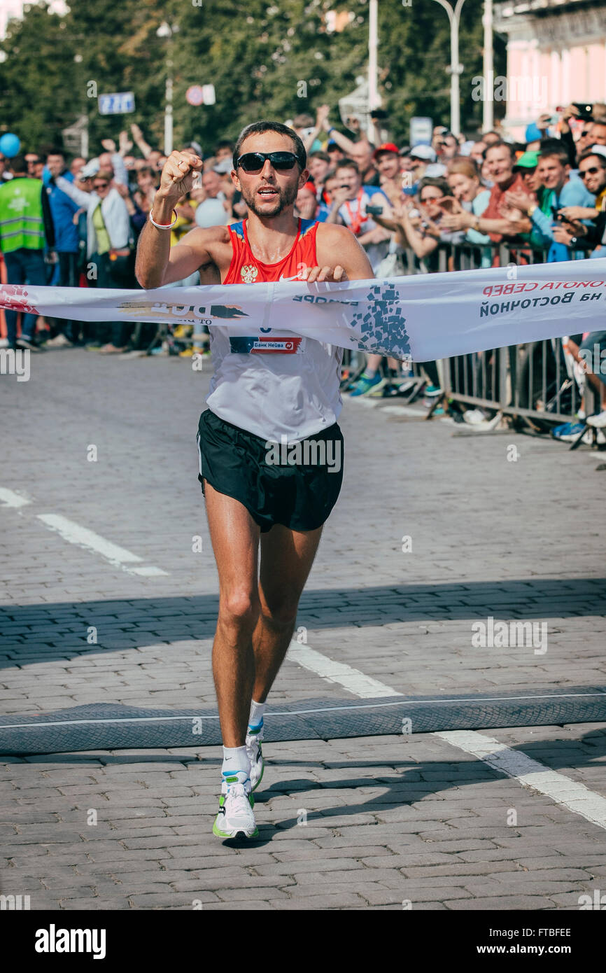 Jekaterinburg, Russland - 1. August 2015: männlicher Athlet-Marathon-Siegerin durchzieht Ziellinie Stockfoto