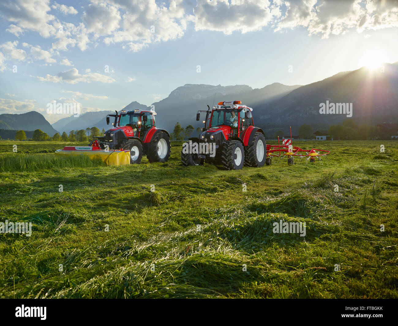 Zwei Traktoren Mähen und Zetten Schnitt Heu, Kundl, Inntal, Tirol, Österreich Stockfoto