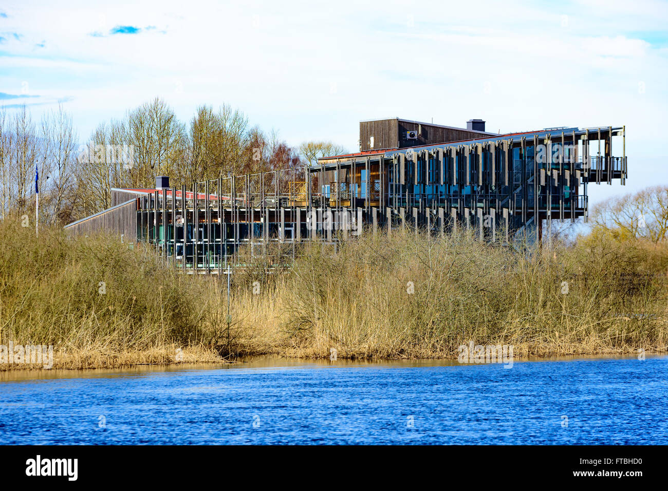 Kristianstad, Schweden - 20. März 2016: The Vattenriket Naturum Gebäude von jenseits des Flusses. Der Fluss fließt in die foreg Stockfoto