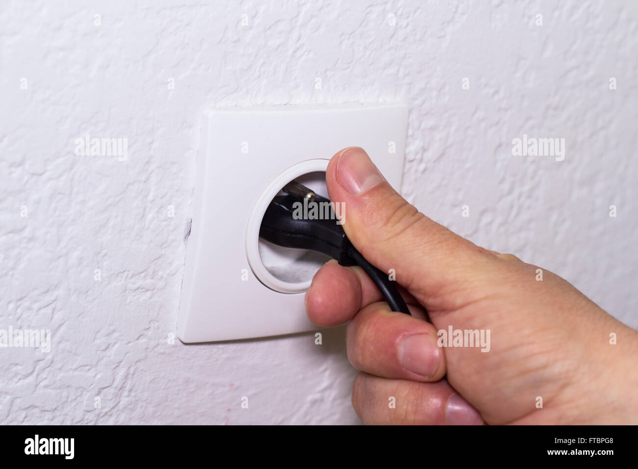 Hand-Stecker Netzkabel in die Steckdose Stockfoto