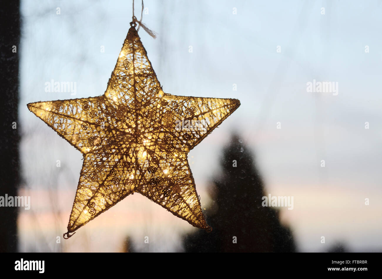 Weihnachtsstern in einem Fenster gegen den Abendhimmel Stockfoto