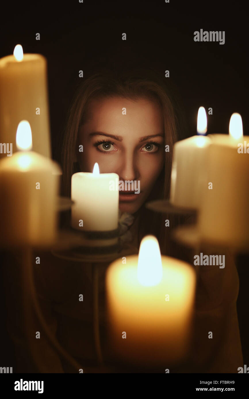 Dunklen Kerzenschein Porträt einer jungen Frau. Gothic und surreale Konzept Stockfoto