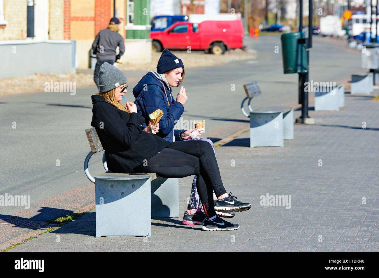 Ahus, Schweden - 20. März 2016: Zwei junge Mädchen von der Hafenpromenade Eis essen. Das Wetter ist sonnig und feine Stockfoto