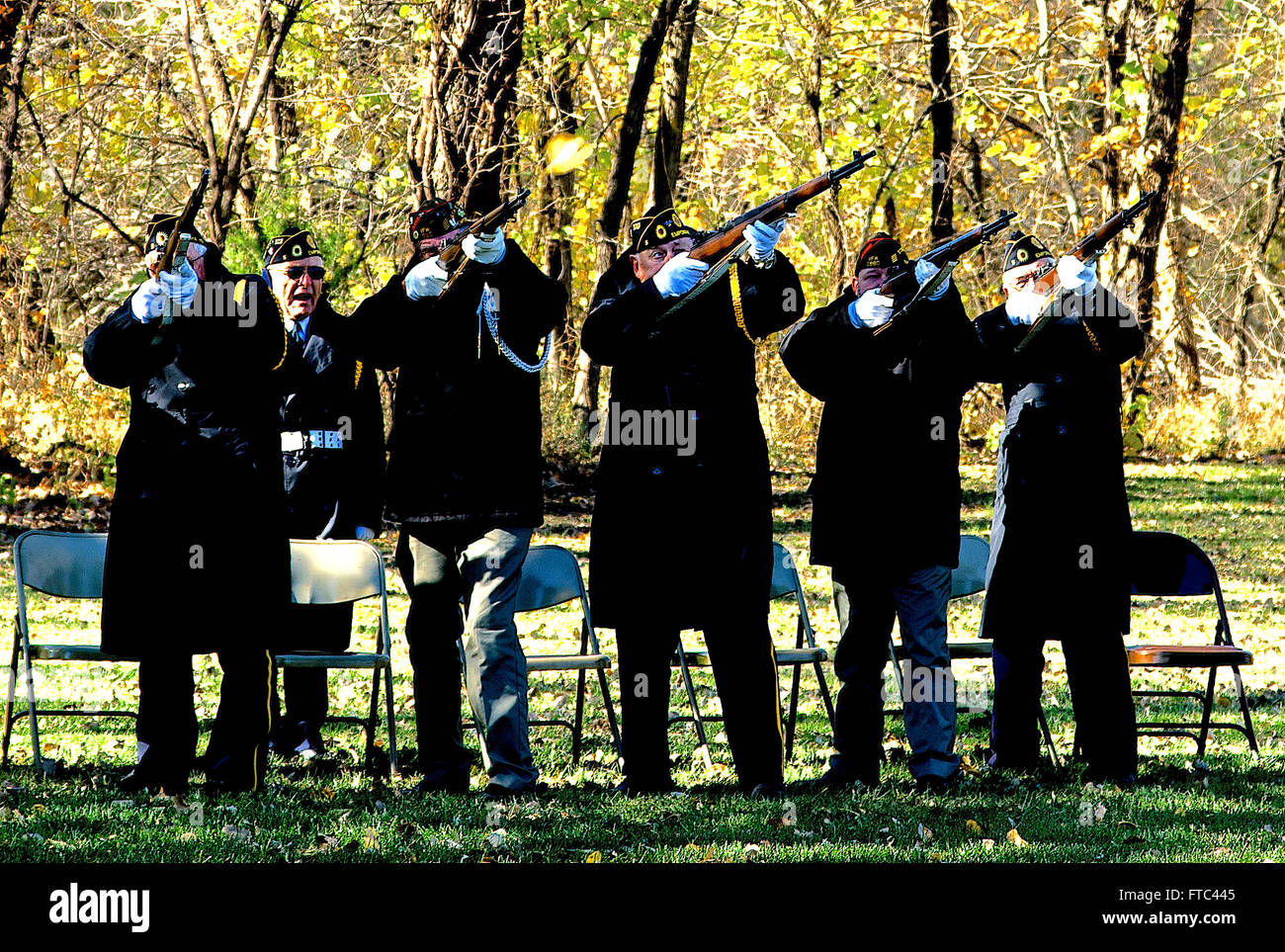 Emporia, Kansas, USA, 11. November 2014 Mitglieder der American Legion Post #5 des Emporia Kansas Feuer 3-Volley Salute, das signalisiert das Ende der Trauerfeier. Beachten Sie die Flammen aus dem Lauf der Waffe die 2.v.l. Der 3-Volley Salute ist ein Festakt am Militär und Polizei Beerdigungen im Rahmen des Bohrers und Zeremonie von der Ehrengarde. Es besteht aus einer Gewehr Party feuern Platzpatronen in die Luft drei Mal. Der Brauch stammt aus der Europäischen dynastische Kriege, wo nicht mehr die Kämpfe so die Toten und verletzten entfernt werden konnte.  Bildnachweis: Mark Reinstein Stockfoto