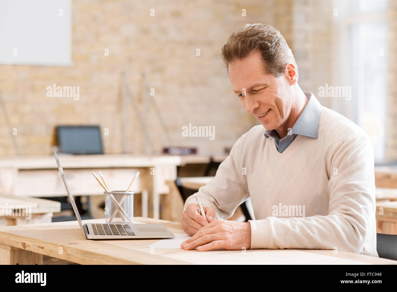 Positive Menschen, die am Tisch sitzen Stockfoto