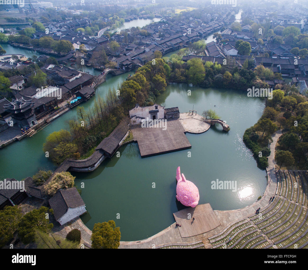 Tongxiang, China. 27. März 2016. Foto aufgenommen am 27. März 2016 zeigt eine riesige Rosa "Floating Fish" Wassertheater in Wuzhen, Ost-China Zhejiang Provinz. Rosa "Floating Fish" ist ein Stück der Werke von Florentijn Hofman, wer ist auch wissen, eine riesige "Rubber Duck" in Hong Kong im Jahr 2013 für die Wuzhen internationale zeitgenössische Kunstausstellung zu schaffen. Die "schwimmenden Fisch" setzt sich aus schwimmenden Platten zum Schwimmen. Die Ausstellung wird hier vom 28. März bis 26. Juni stattfinden. Bildnachweis: Xinhua/Alamy Live-Nachrichten Stockfoto