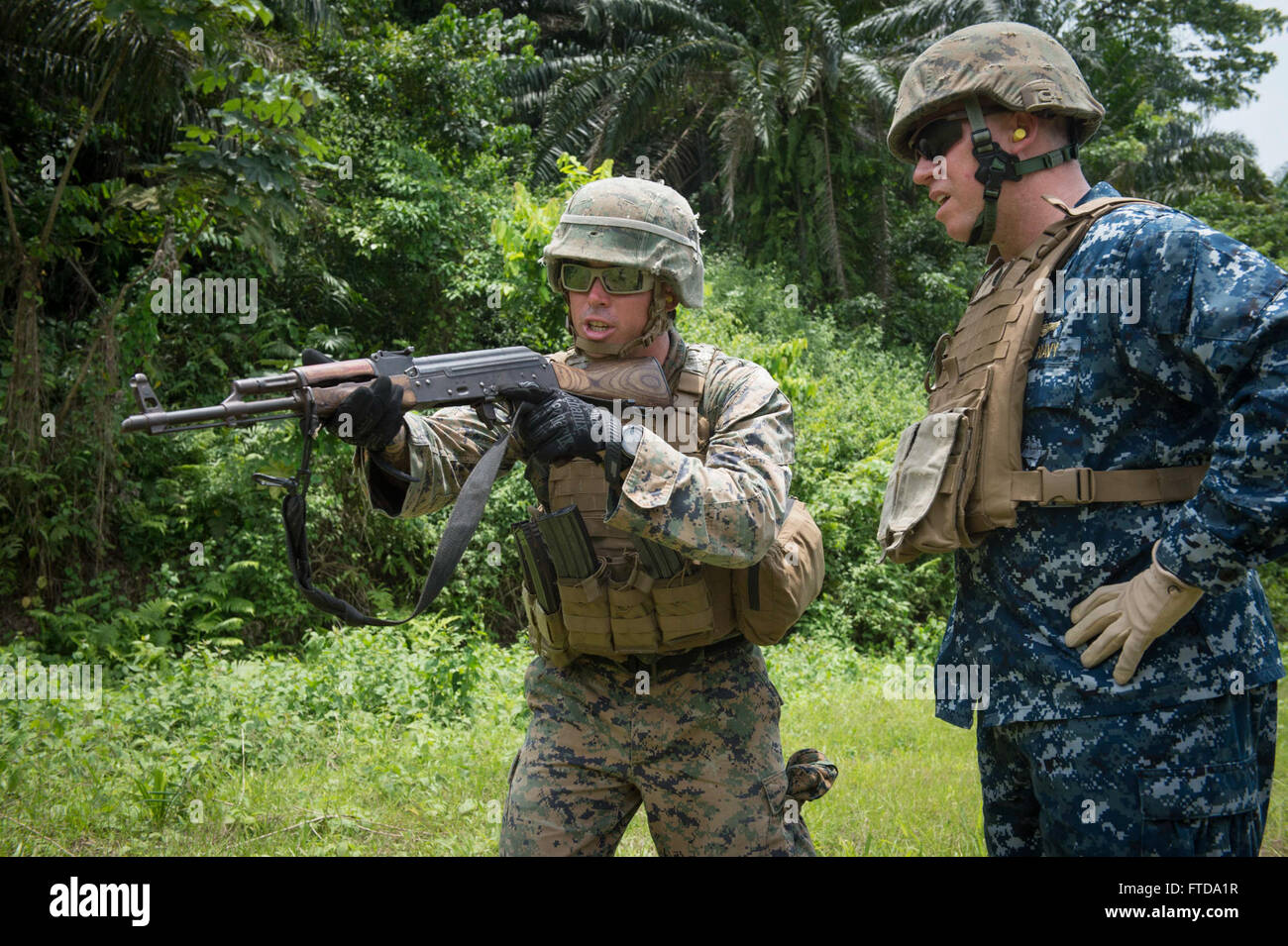 150314-N-JP249-058 ISSONGO, Kamerun (14. März 2015) Marine Sgt. Benjamin Sheely, links, gibt Anweisungen in USA 6. Flotte Vice Kommandant Rear Admiral Tom Reck auf wie ein AK-47 Sturmgewehr auf einem Schießplatz Feuer während Afrika Partnerschaft Stationon 14. März 2015, in Issongo, Kamerun. , Afrika-Partnerschaft-Station, ein internationales Programm für kollaborative Kapazitäten im Zusammenhang mit einer geplanten Bereitstellung von Military Sealift Command gemeinsame High-Speed-Schiff USNS Speerspitze (JHSV 1) durchgeführt wird. (Foto: U.S. Navy Mass Communication Specialist 2. Klasse Kenan O'Con Stockfoto