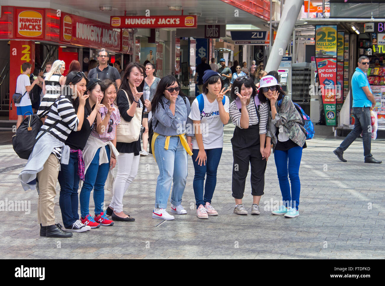 Chinesische Touristen posieren für ein Foto in Queen Street Mall, Brisbane, Australien Stockfoto