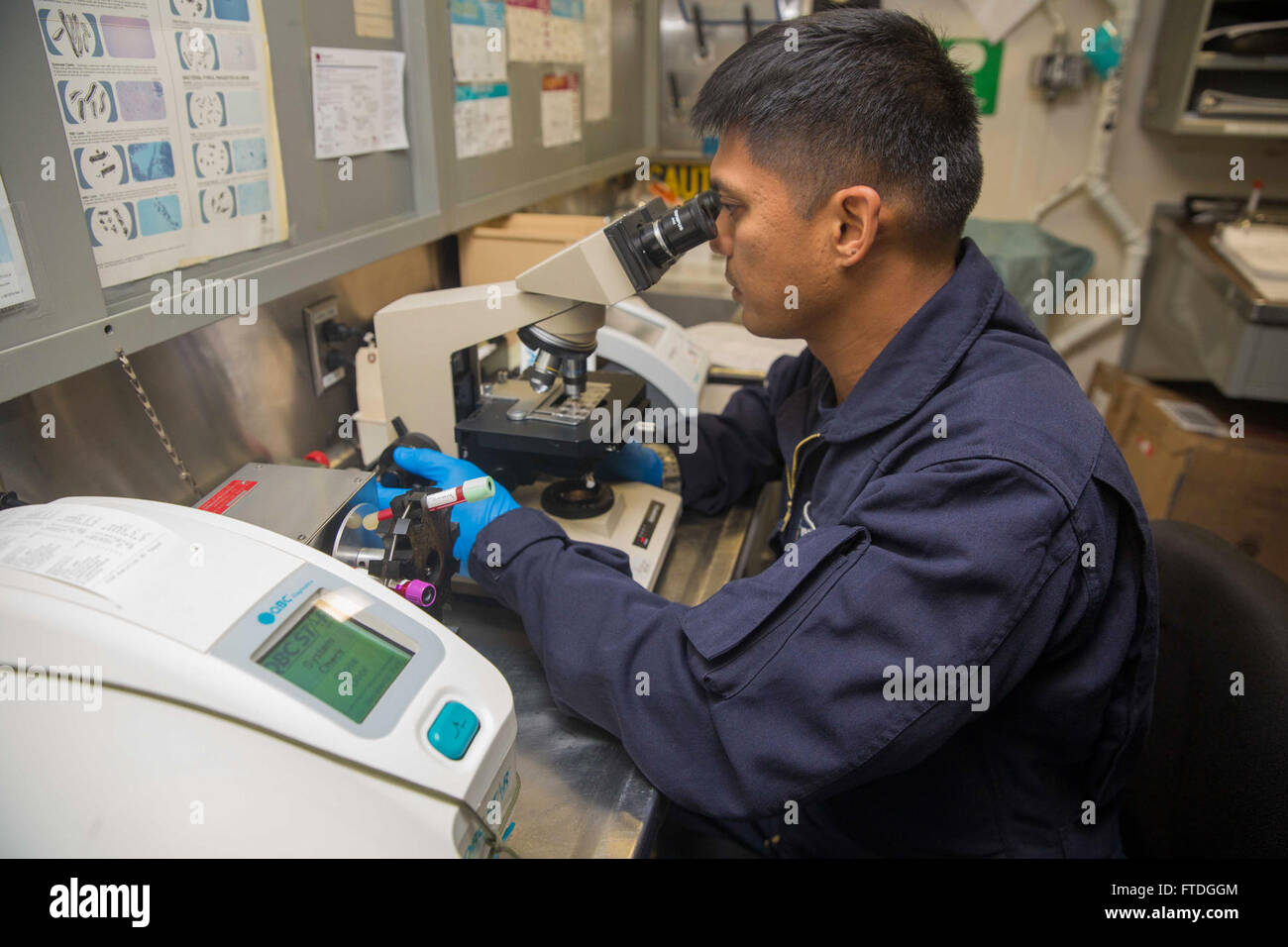 151017-N-KW492-141 Atlantik (17. Oktober 2015) Hospital Corpsman 1. Klasse Phillip Manalili, der führenden Petty Officer der Flotte chirurgischen Team 4, untersucht einen Objektträger in das medizinische Labor der amphibischen Angriff Schiff USS Kearsarge (LHD-3) 17. Oktober 2015. Kearsarge, eingesetzt als Teil der Kearsarge amphibische Gruppe bereit, führt Marinebetriebe in den USA 6. Flotte Bereich der Maßnahmen zur Erhöhung der Sicherheit der Vereinigten Staaten in Europa interessiert. (US Navy Foto von Massenkommunikation Spezialist Seemann Lehrling Ryre Arciaga/freigegeben) Stockfoto