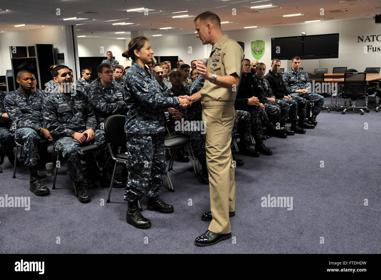 151027-F-LG169-013 RAF MOLESWORTH, Vereinigtes Königreich (27. Oktober 2015) Naval Forces Europe-Africa Fleet Master Chief Steven Giordano, Recht, Münzen einen Seemann während eines Anrufs alle Hände an RAF Molesworth, Vereinigtes Königreich, 27. Oktober 2015. Giordano Besuch diente dazu, die Befehle Qualität der Arbeit und der Lebensqualität sowie Anerkennung vorbildlicher Servicemembers besser zu verstehen. (US Air Force Foto von Staff Sgt Ashley Hawkins/freigegeben) Stockfoto