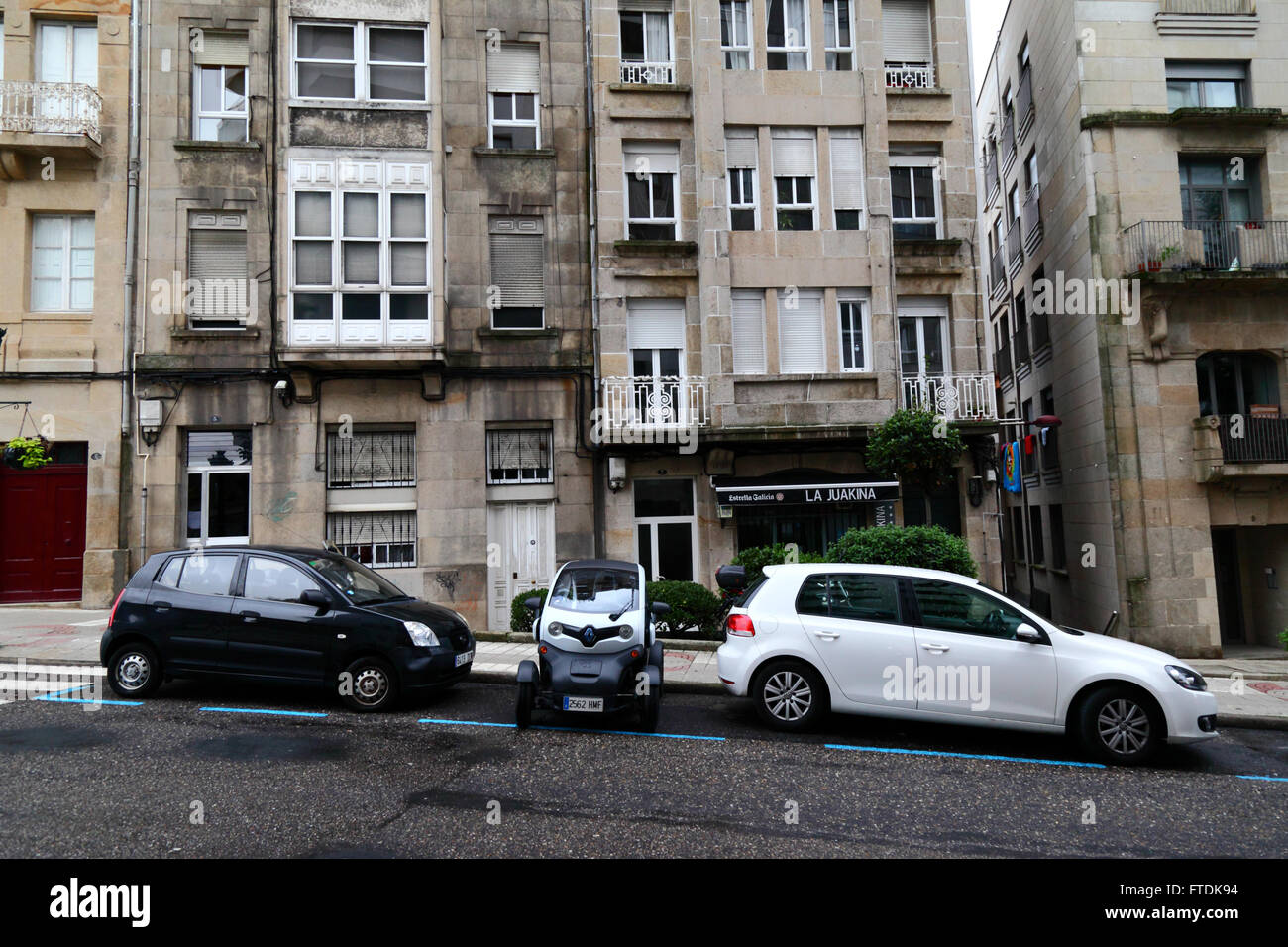 Renault Twizy Vierrad-Kleinwagen geparkt seitwärts zwischen 2 normalen Autos in der Straße, Vigo, Galicien, Spanien Stockfoto