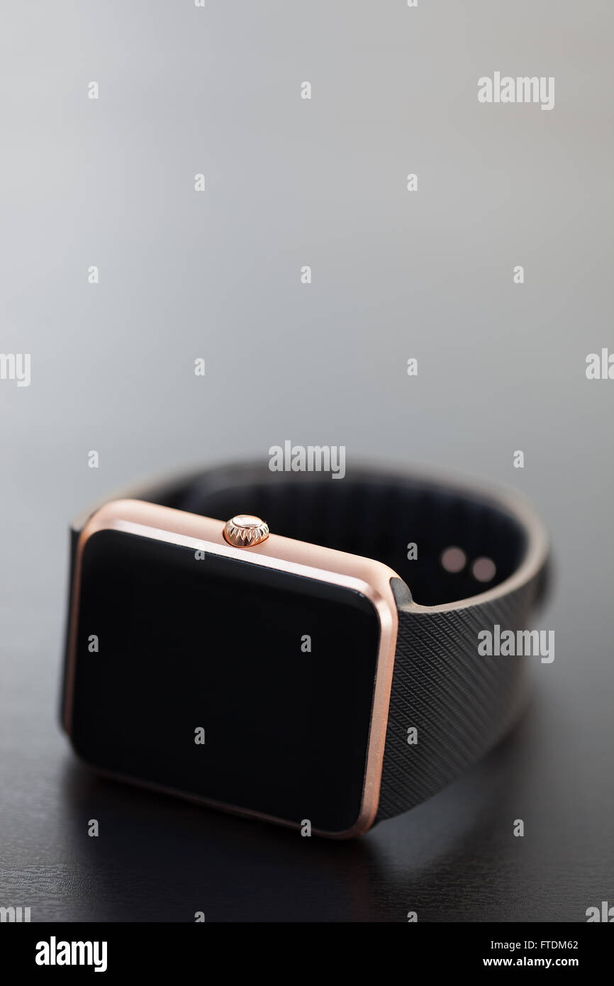 Makrofoto des modernen stilvollen Smartwatch auf dem Tisch liegen. Neue Technologie, die bald von allen verwendet werden. Vertikal gedreht, keine Modelle, neutrale Farben Stockfoto