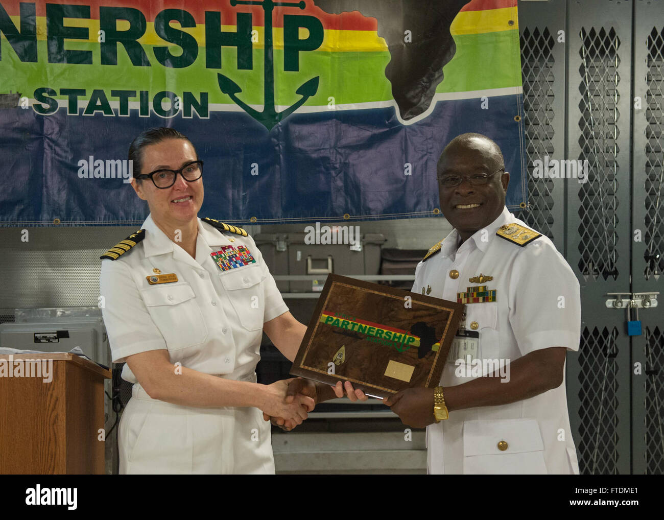 160216-N-QF605-064 SEKONDI, Ghana (16. Februar 2016) - Captain Heidi Agle, Commodore, Military Sealift Command Europa und Afrika, präsentiert eine Gedenktafel für Commodore Mark Ransford Nanabayin Yawson, Flag Officer commanding, Eastern Naval Command, bei der Abschlussfeier der Ghana Teil des afrikanischen Maritime Law Enforcement Partnerschaft Übung an Bord USNS Speerspitze (T-EPF 1) 16. Februar 2016. Das Military Sealift Command expeditionary schnellen Transportschiff USNS Speerspitze auf eine geplante Bereitstellung für US-160216-N-QF605-064 SEKONDI, Ghana (16. Februar 2016) Captain Heidi Agle ist, Commodore, militärische Se Stockfoto