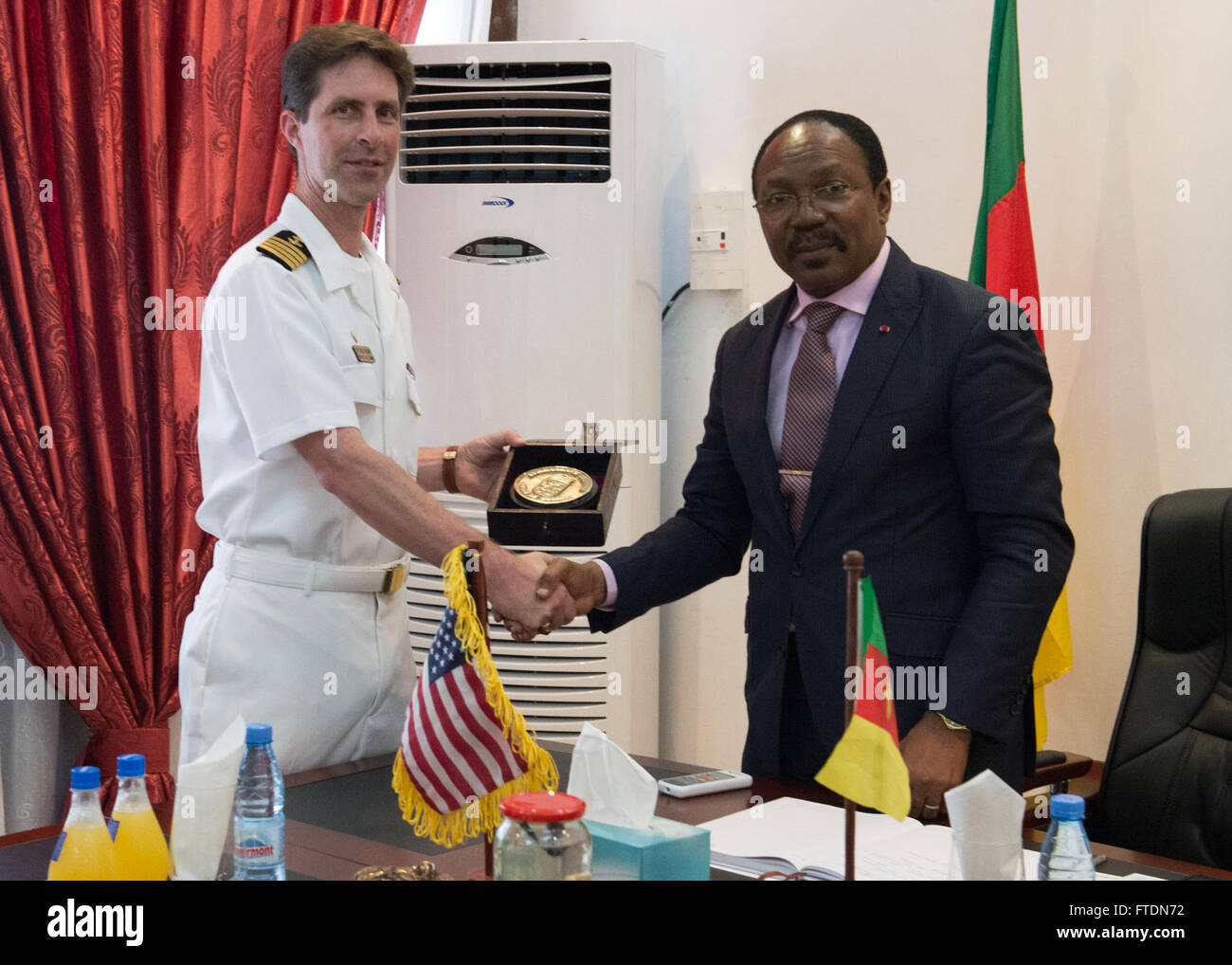 DOUALA, Kamerun (10. März 2016) Captain Douglas Casavant, Meister des Schiffs USNS Speerspitze (T-EPF-1), erhält ein Geschenk von Gemeinschaft Stellvertretung Dr. Fritz Ntone Ntone in Douala, Kamerun während eines Anrufs Büro, 10. März 2016. Das Military Sealift Command expeditionary schnellen Transportschiff USNS Speerspitze auf eine geplante Bereitstellung in die USA ist 6. Flotte Einsatzgebiet zur Unterstützung der internationalen Zusammenarbeit Kapazitäten Programm Afrika Partnerschaft Station. (Foto: U.S. Navy Mass Communication Specialist 1. Klasse Amanda Dunford/freigegeben) Stockfoto