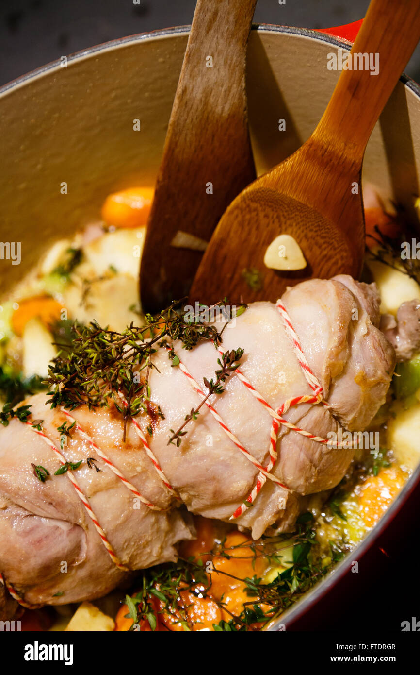 Lammfleisch gerollt Bein mit Kleingeld in einen Topf mit Gemüse, Thymian und Rosmarin Stockfoto