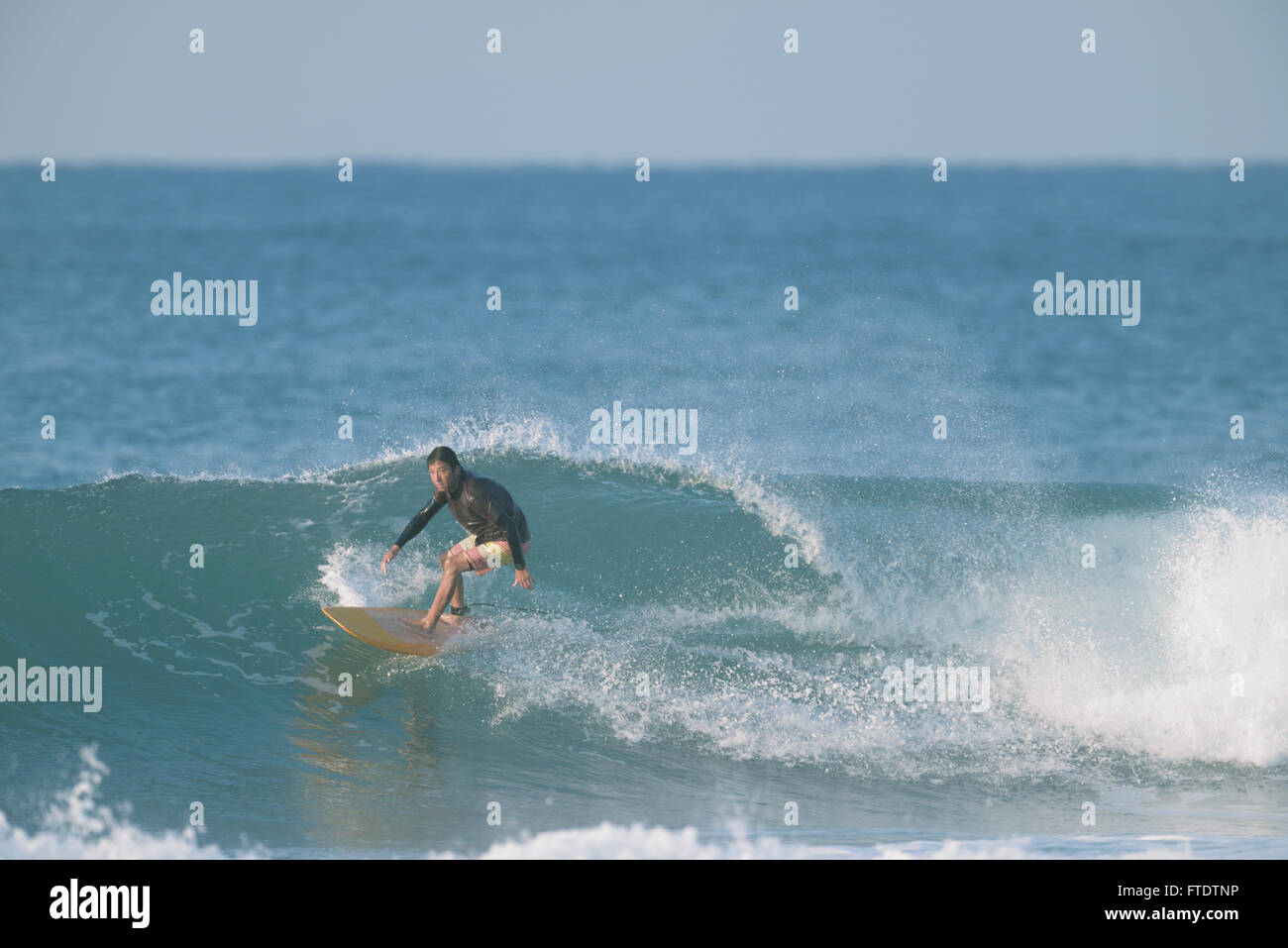 Japanische Surfer Reiten Welle Stockfoto