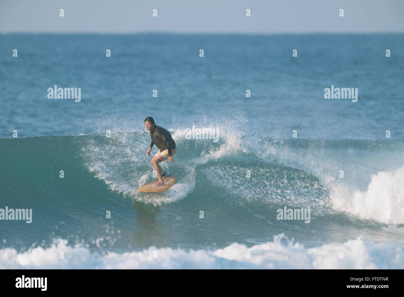 Japanische Surfer Reiten Welle Stockfoto