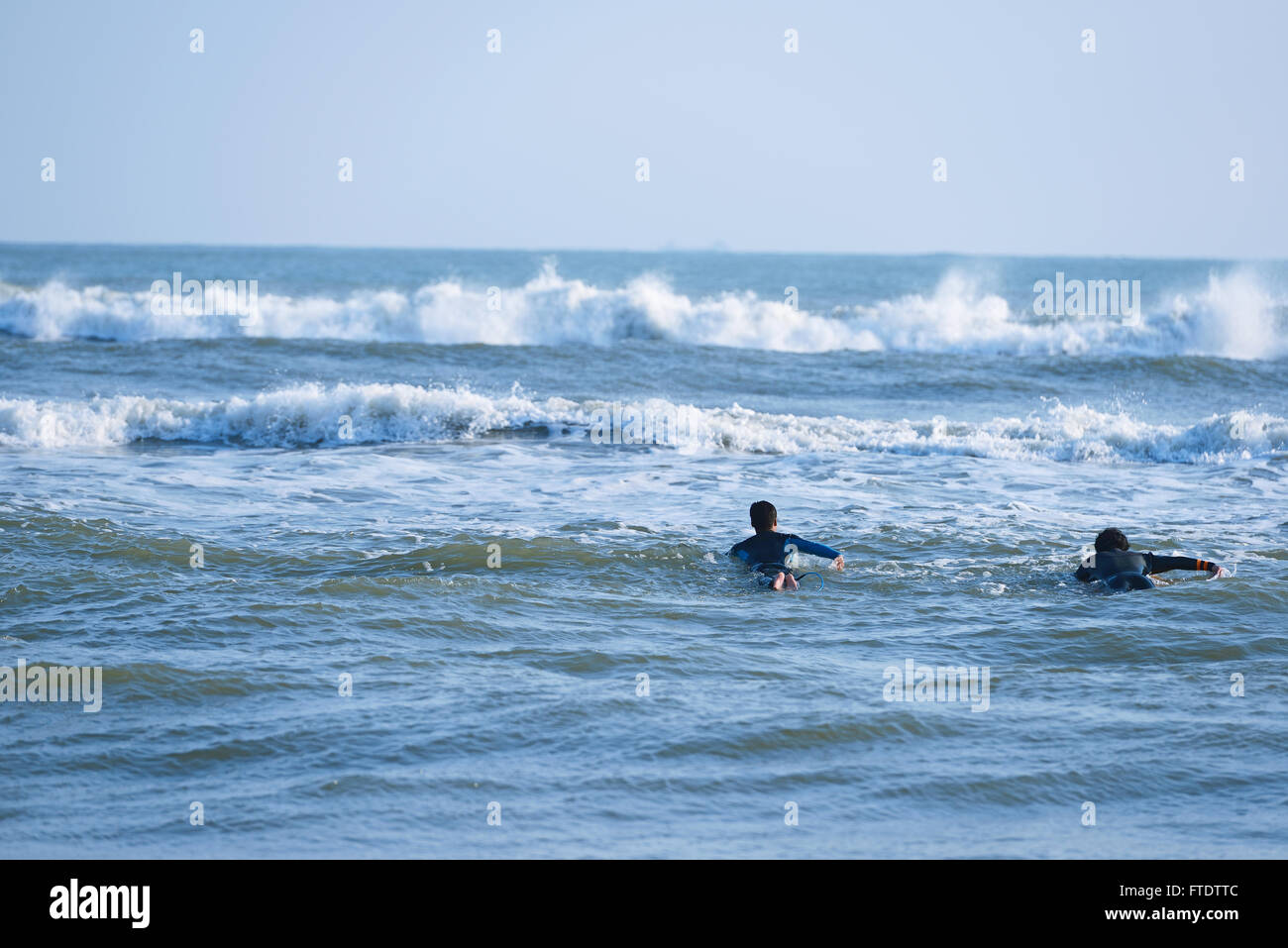 Japanische Surfer paddeln im Meer Stockfoto