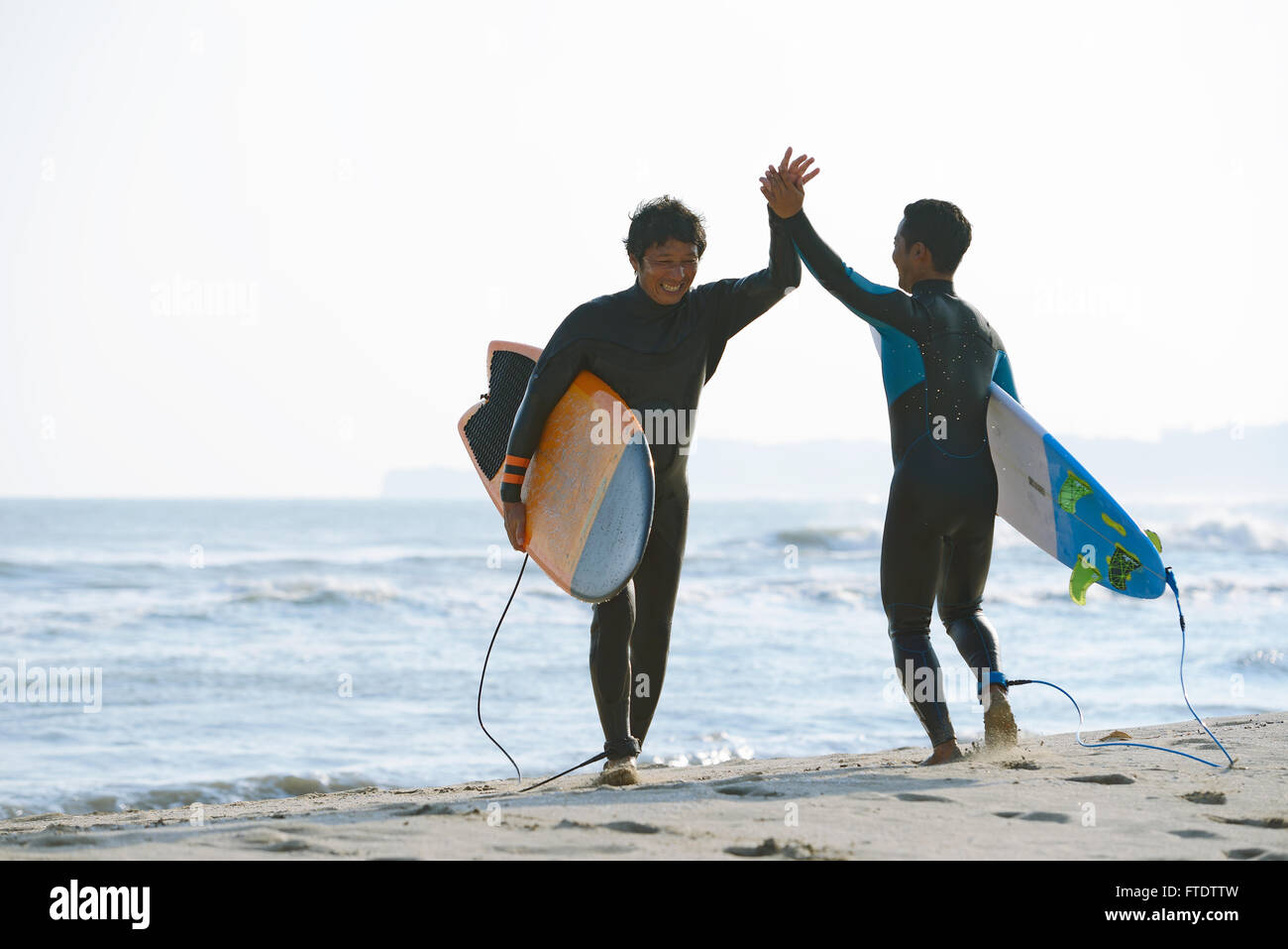 Japanische Surfer am Strand Stockfoto