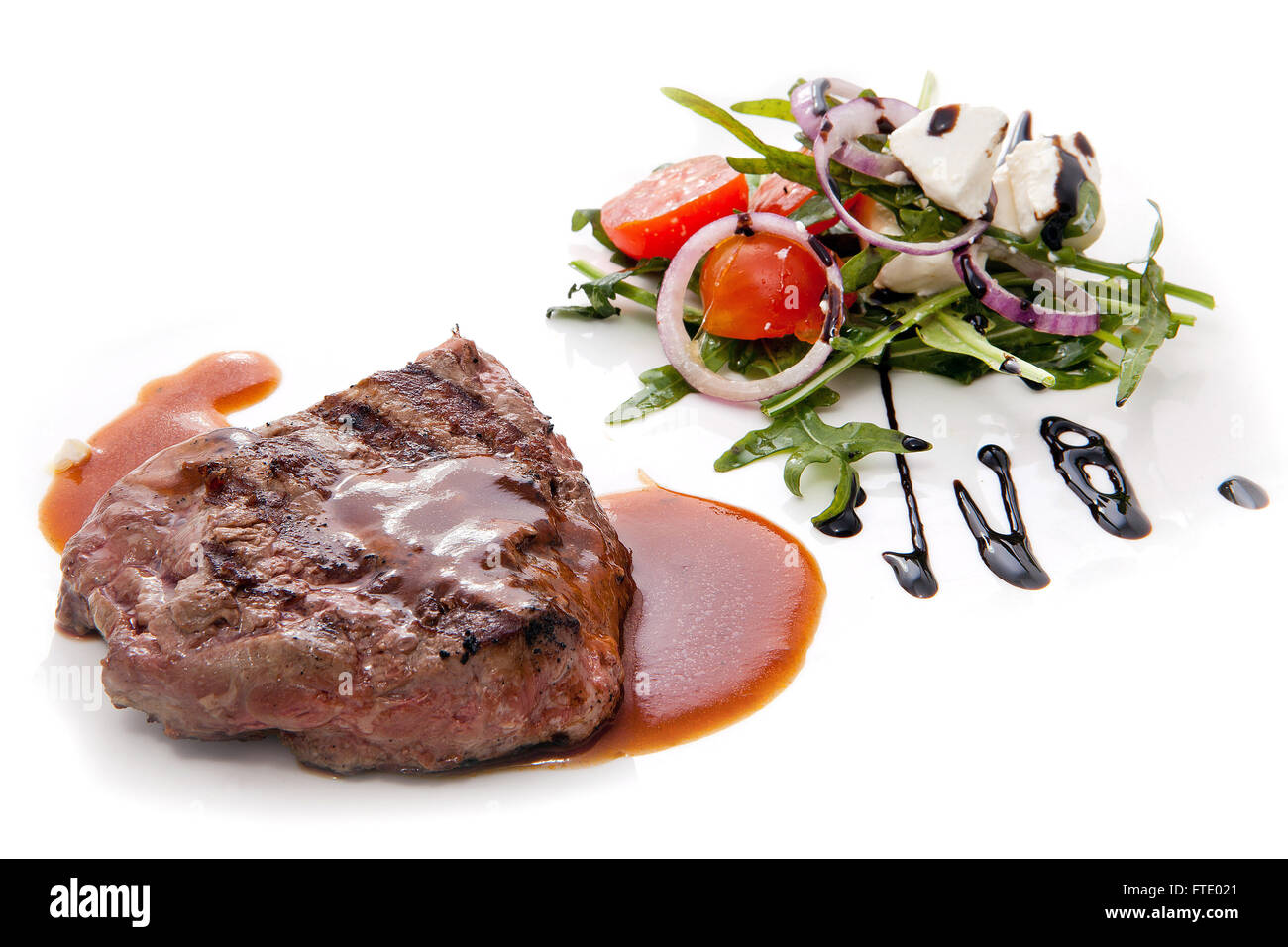 Saftiges gegrilltes Steak serviert mit einem griechischen Salat. Stockfoto