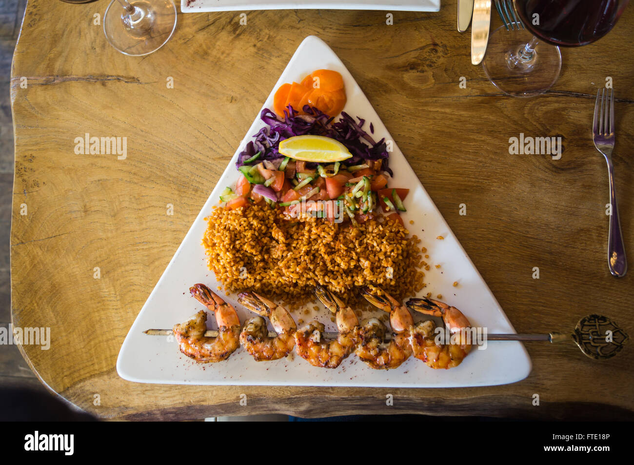 Karides şiş türkischen Knoblauch und Kräuter king Prawn Kebab, Reis und Tomatensalat, Fat Turk Restaurant, Chipping Ongar, Essex, England Stockfoto