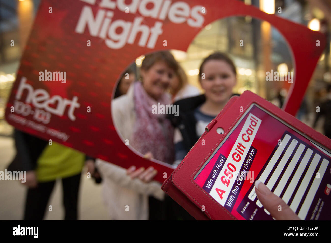 Herz des Radios "Ladies Night" Aktionen für Shopper in The Centre Shopping Mall, Livingston, Schottland. Stockfoto